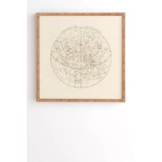 a white wall with a brown frame hanging on it and a map in the middle