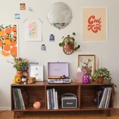 there is a shelf with various items on it and some pictures above the shelves in the room