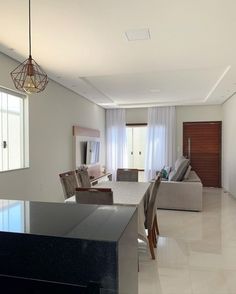 a kitchen and living room are shown in this modern style home with white tile flooring