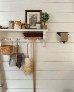 there are two brooms hanging on the wall next to some towels and other items