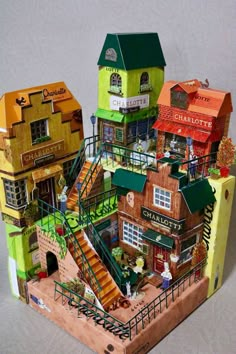 an assortment of miniature houses are shown in this image, including one with a green roof