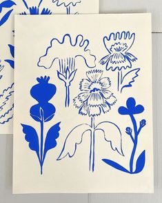 two blue and white flower designs on paper