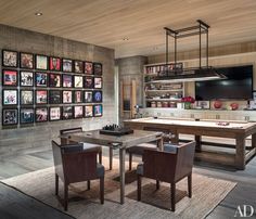 a dining room with a pool table, chairs and pictures on the wall behind it