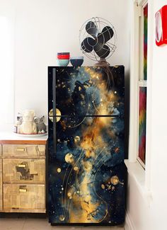 a black refrigerator with gold and blue designs on it