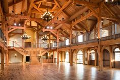 the inside of a large building with wooden floors and chandeliers hanging from the ceiling