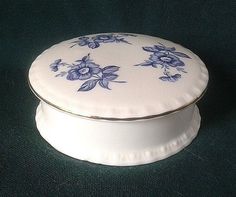 a white box with blue flowers on it sitting on a green tableclothed surface