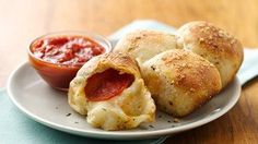 two pieces of pizza on a plate with dipping sauce