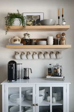 the shelves are filled with dishes, cups and other kitchen items on top of them