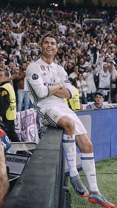 a man sitting on top of a bench in front of a crowd