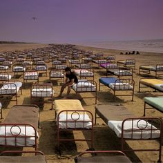 there is a man standing in the middle of rows of beds that are all empty