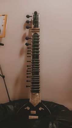 a guitar sitting on top of a black cushion