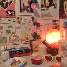 a table topped with plates and cups next to a vase filled with flowers on top of it