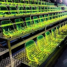 rows of green plastic chairs sitting on top of metal racks