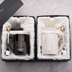 two black and white coffee mugs with gold stars on them in a gift box