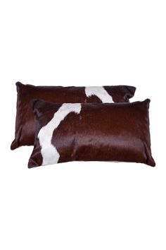 two brown and white cow hide pillows