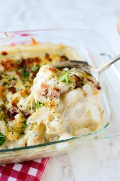 a casserole dish with broccoli, cheese and other items in it