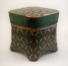 a green and brown box sitting on top of a white table