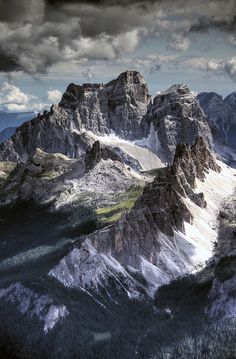 the mountains are covered in snow and clouds