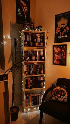 a room filled with lots of books and posters on the wall next to a chair