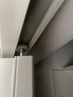 a close up view of the corner of a white door with a light on it