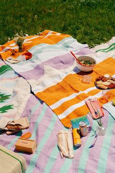 a picnic blanket with food and drinks on it