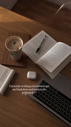 an open book sitting on top of a wooden table next to a keyboard and mouse