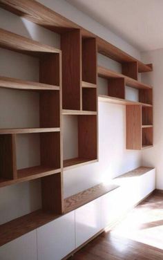 an empty room with wooden shelves and white walls