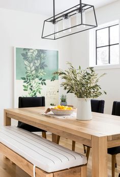 a dining room table with a bowl of fruit on it