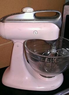 a pink mixer sitting on top of a counter