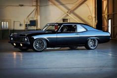 a black muscle car parked in a garage