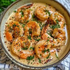 a bowl filled with shrimp and sauce on top of a table