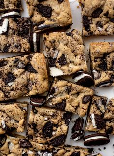 chocolate chip cookies and oreo cookie bars are arranged on a white platter for dessert