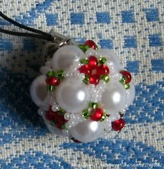 a white beaded ornament with red and green beads