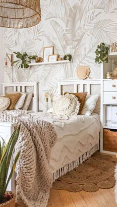 a bedroom with white furniture and plants on the wall above the bed, along with a wicker basket hanging from the ceiling