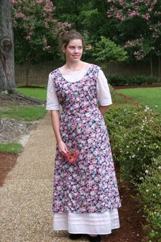 a woman in a dress standing on a path