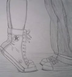 a pencil drawing of two feet with shoes on the ground next to eachother