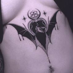 a woman's stomach with a bat tattoo on it