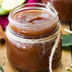 an apple cider in a glass jar on a wooden table