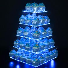 a blue lighted christmas tree with cupcakes on it's sides and the words note batteries not included