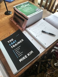 a book sitting on top of a wooden table next to a pen and paper bag