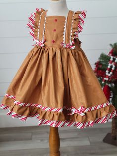 Girls Gingerbread Dress Adorable girls Gingerbread Dress! Features fun trim and ties in back. Gingerbread Christmas Dress, Fitted Ruffle Holiday Dress For Dress-up, Fitted Ruffle Holiday Dress For Dress-up Events, Sleeveless Ruffled Holiday Dress, Formal Fitted Ruffle Holiday Dress, Christmas Sleeveless Ruffled Holiday Dress, Christmas Sleeveless Ruffle Holiday Dress, Sleeveless Ruffled Christmas Holiday Dress, Sleeveless Ruffled Holiday Dress For Christmas