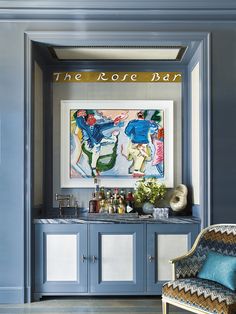 a blue and white room with a painting on the wall