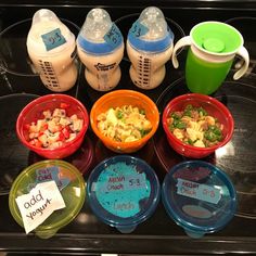 baby bottles and bowls with food in them sitting on a counter next to each other