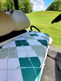 the back seat of a golf cart with a green and white checkered cloth on it