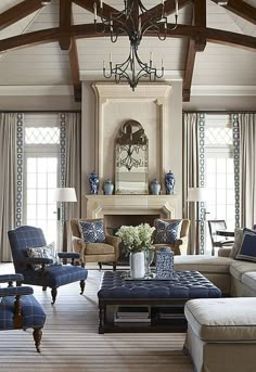 a living room with couches, chairs and a chandelier hanging from the ceiling