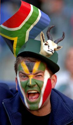 a man with his face painted in the colors of south african flag and goat's head