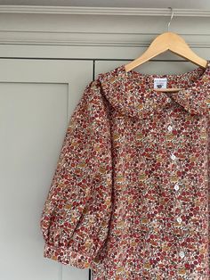 "Hand made Liberty of London floral print Tana Lawn Peter Pan ruffle collar blouse with 3/4 sleeves. *Loose fitting blouse in beautiful liberty print cotton fabric with a ruffle collar and button through front.  *Full 3/4 sleeves have pretty gathers at the sleeve head and cuff.  *Bust darts * Liberty Tana lawn is a luxurious, fine cotton fabric with a silky handle. It is very soft and comfortable to wear. Made to order by me in my studio in East Sussex. Please check my shop announcement for curr Liberty Print Blouse, Classy Tops, Peter Pan Blouse, Peter Pan Collar Top, Blouse With Collar, Ruffle Collar Blouse, Teacher Clothes, Peter Pan Collar Blouse, Peter Pan Collars