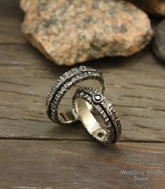 two silver rings sitting on top of a wooden table