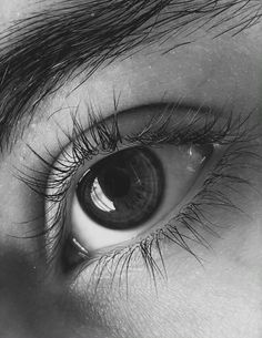 an eye with long lashes is shown in black and white