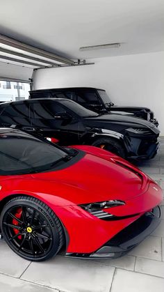 a red sports car is parked in a showroom with other cars on the floor